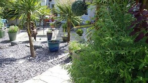 A courtyard with potted plants, a small table, and chairs.
