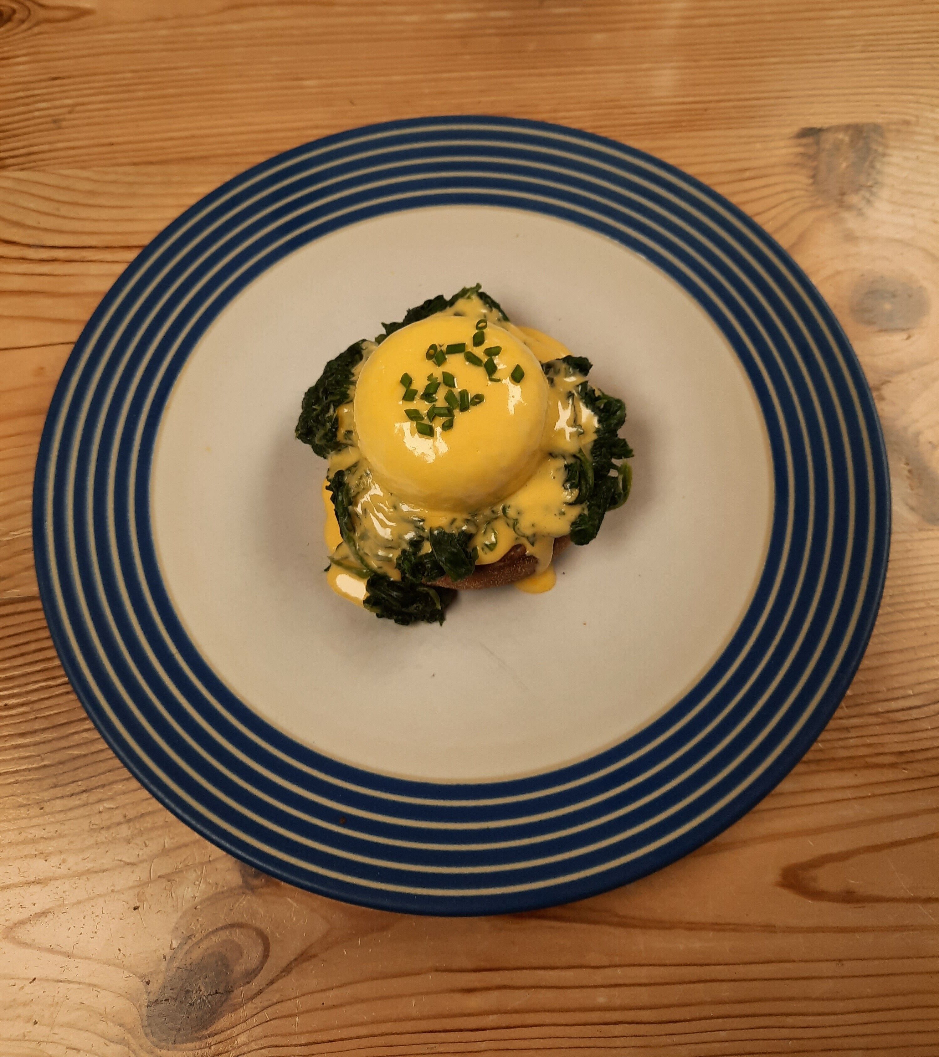 A plate with a dish on a wooden table.