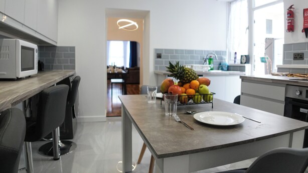 Cozinha moderna com ilha central, micro-ondas e uma fruteira.