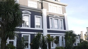 Een gebouw met twee verdiepingen, witte raamkozijnen en een donkere gevel.