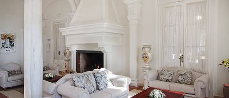 A spacious living room with a fireplace, two sofas, and a coffee table.