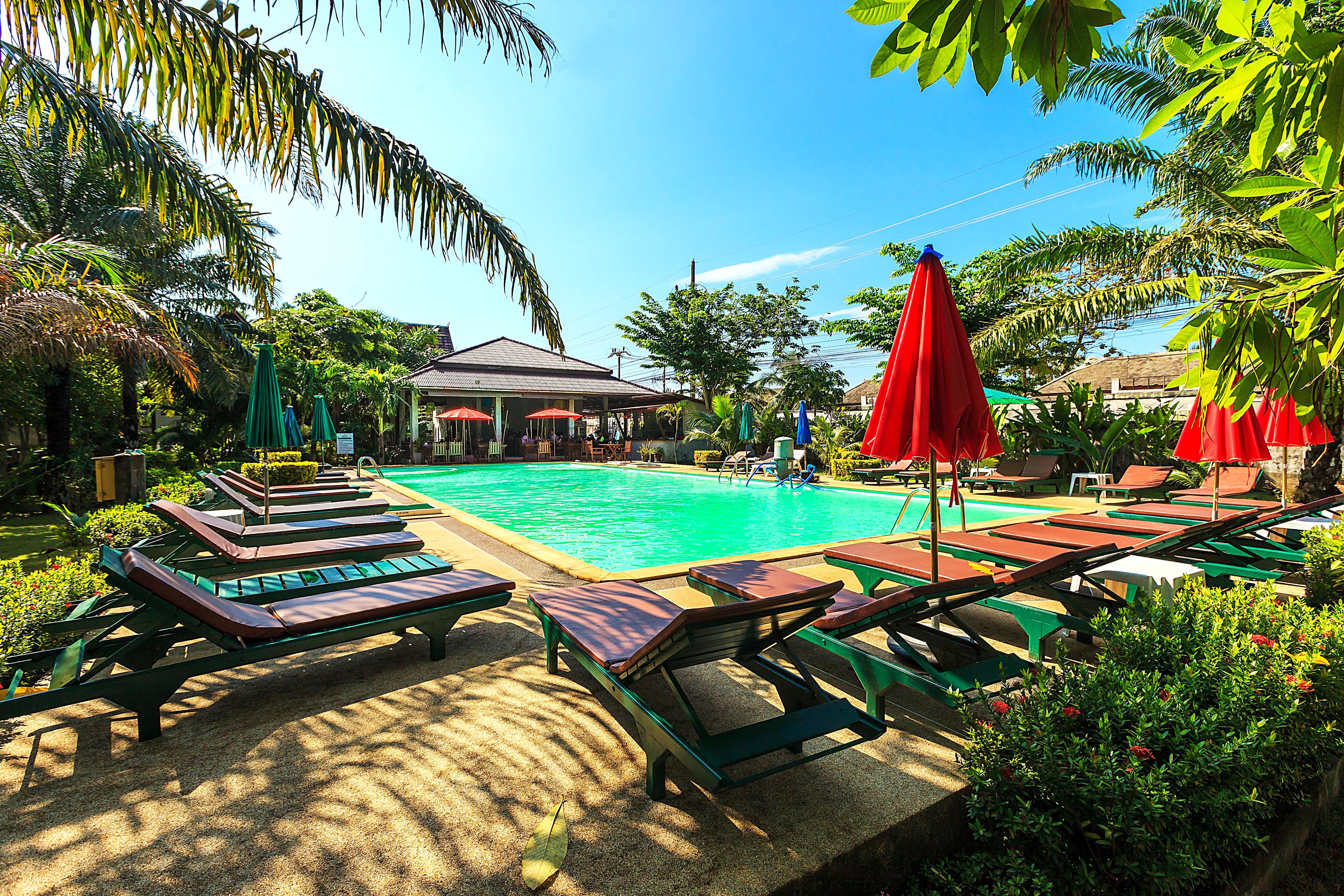 A pool area with lounge chairs and umbrellas.