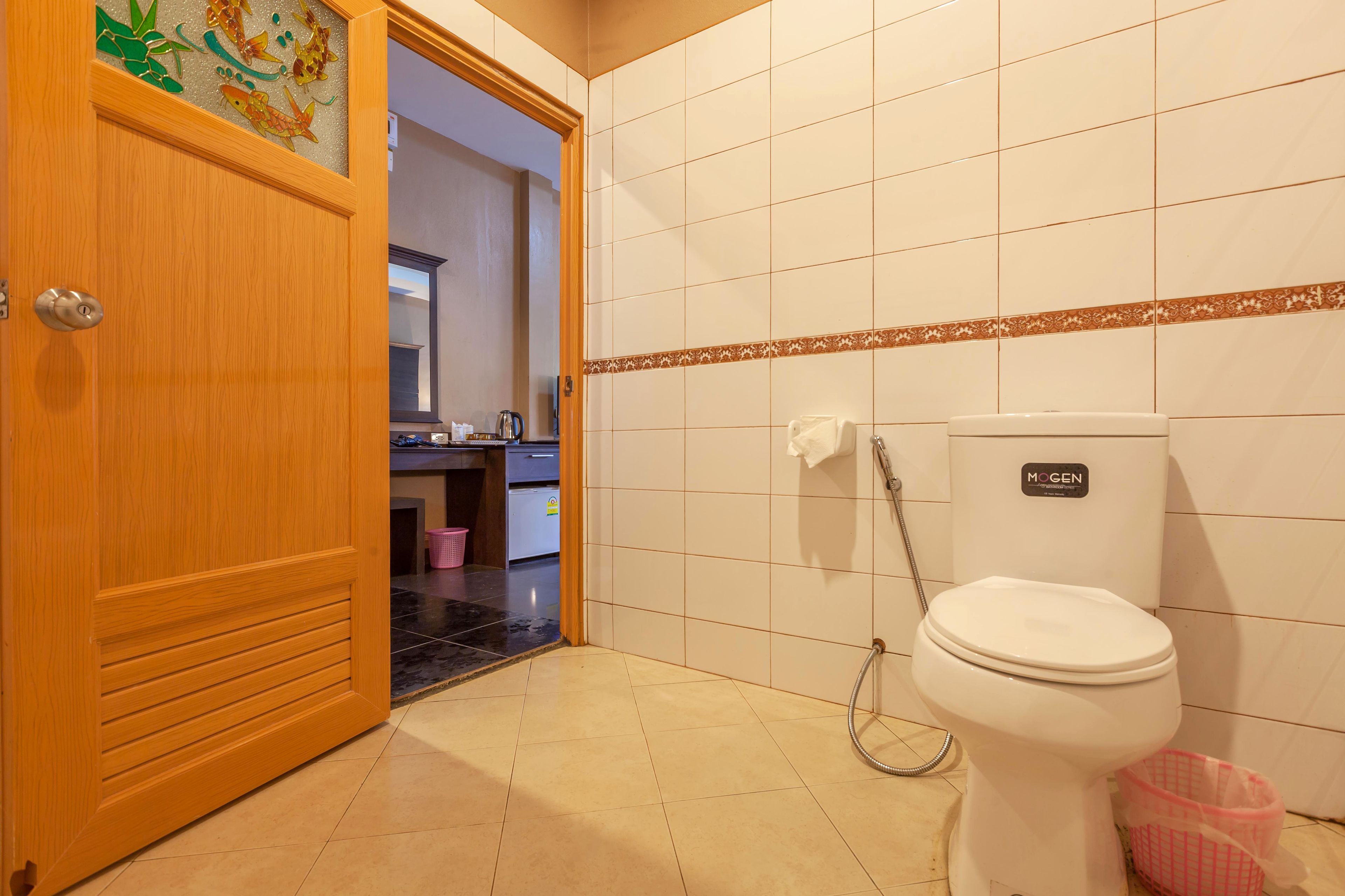 A bathroom with a toilet, a shower, and a sink.