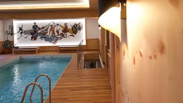 Una piscina techada, sillones reclinables de piscina