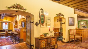 Un interior tradicional con una zona de bar, muebles de madera y decoraciones ornamentales.