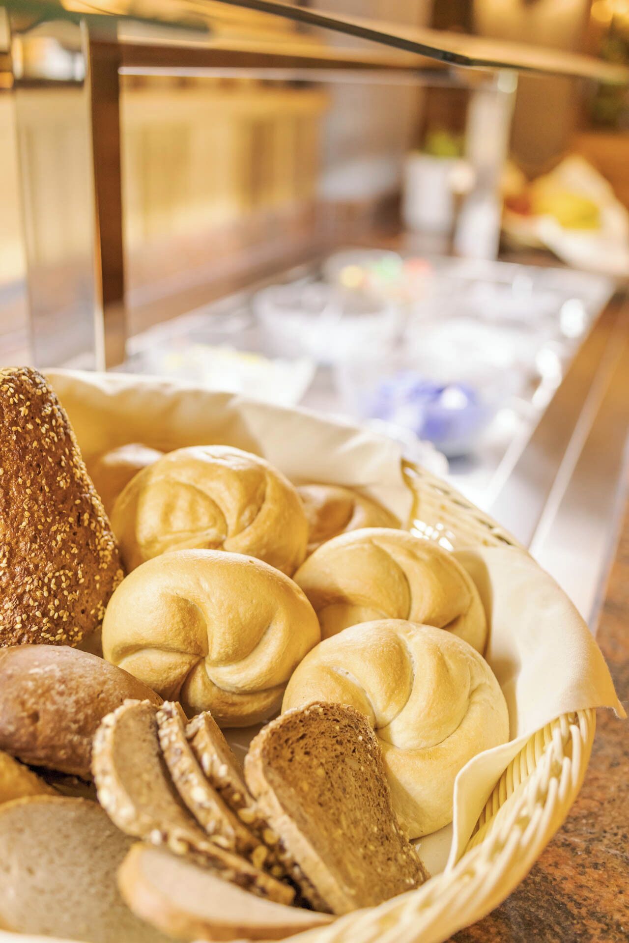 A display case with various baked goods including bread and pastries.