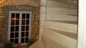 Una escalera de piedra que lleva a un ventanal con marco blanco.