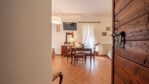 Un comedor con una mesa y sillas de madera, una lámpara y un radiador.