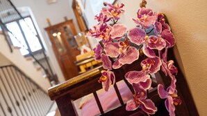 Una escalera con barandilla de madera y un detalle decorativo floral.