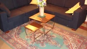 A dark blue sofa with a small wooden table and a vase of flowers in the center. - Teatro Bellini - Bed & Breakfast (Catania)