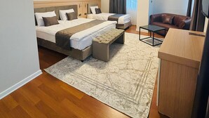 Quarto de hotel com uma cama grande, uma escrivaninha, uma cadeira e uma televisão.