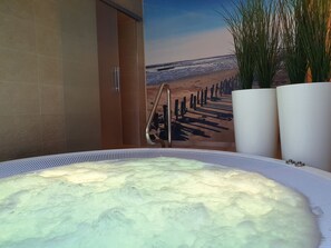 A hot tub with a view of a beach and a wooden pier. - Hotel Friesische Wehde (Bockhorn)