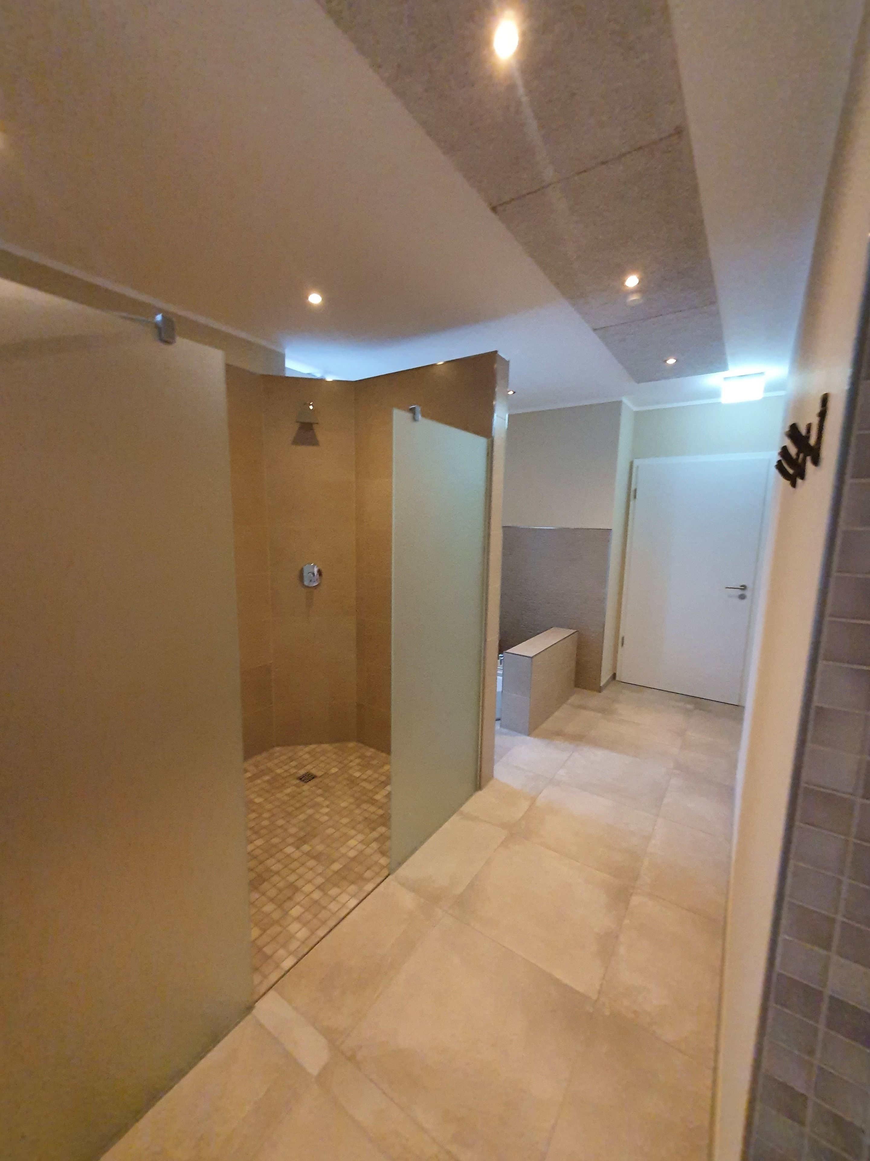 A modern bathroom with a shower, toilet, and sink.
