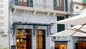 A hotel with a balcony and a cafe in front. - Hotel La Vila (Sóller)