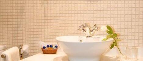A bathroom with a white sink, two mirrors, and a towel rack.