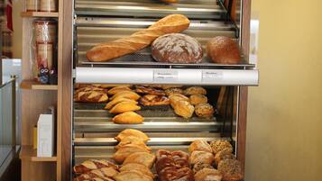 Eine Bäckereiauslage mit verschiedenen Brotsorten und Backwaren, darunter Etiketten mit den Namen der Brotsorten.