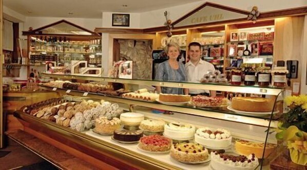 Un expositor de pastelería con diversos pasteles y tartas.