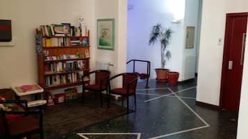 Cozy hallway with a bookshelf, chairs, and a potted plant.