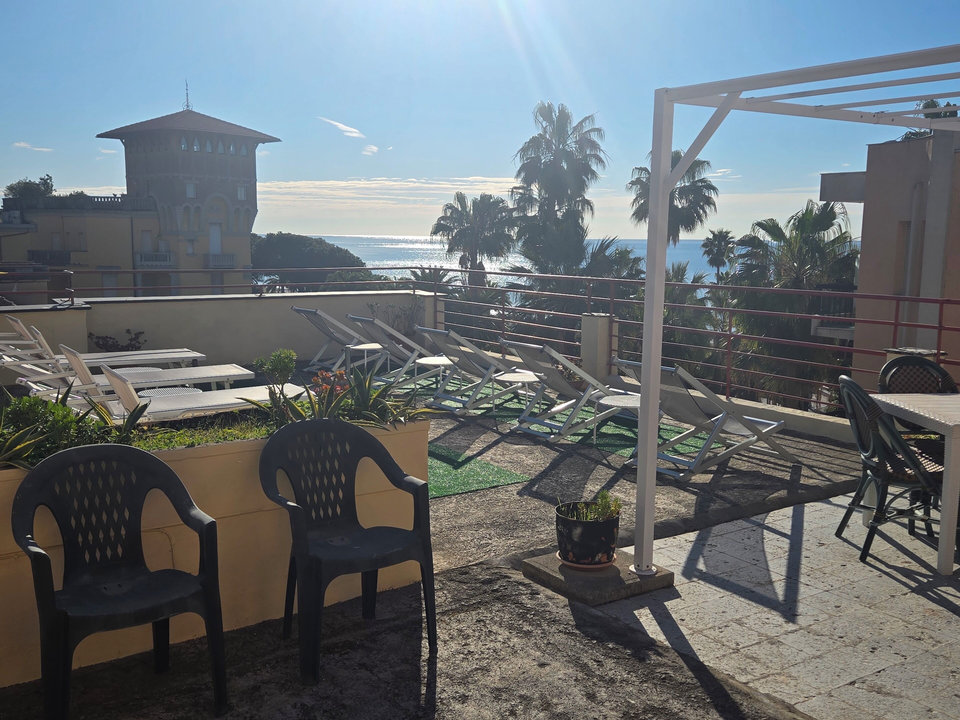Una terraza en la azotea con sillones de descanso, una mesa y vistas al mar.