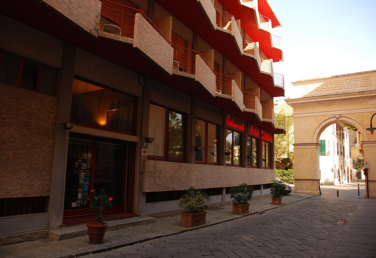 A building with multiple balconies and a restaurant with a red sign.