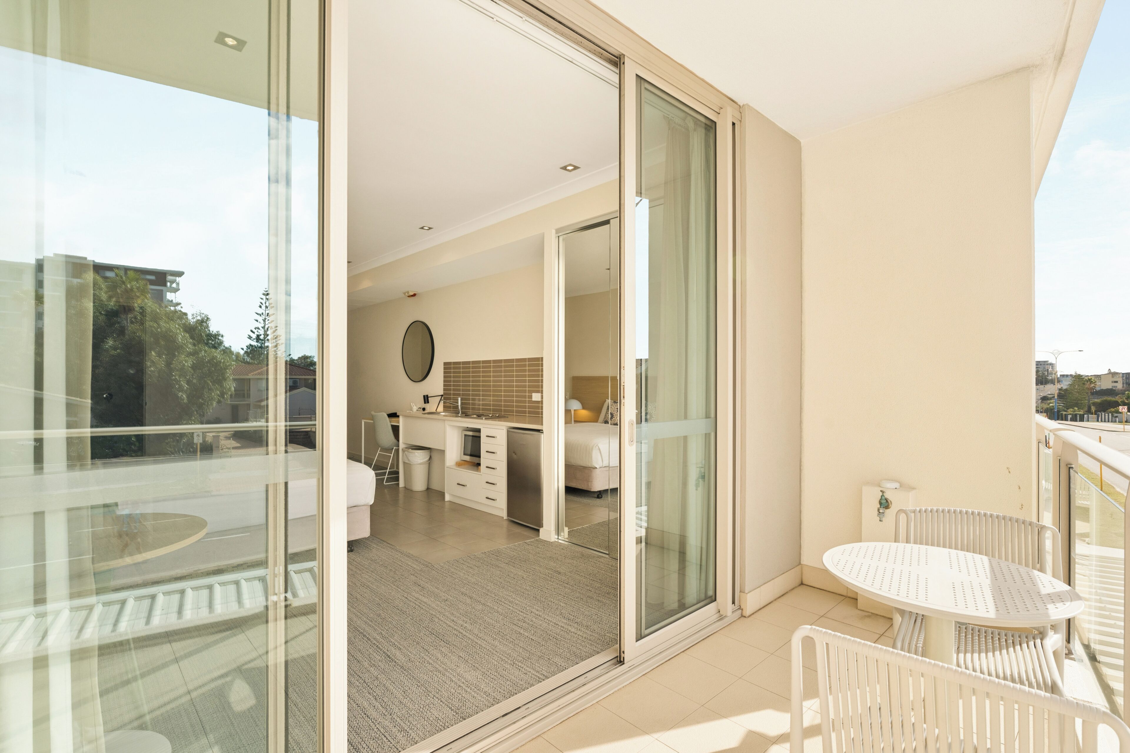Um apartamento moderno com varanda, área de refeições e um quarto.