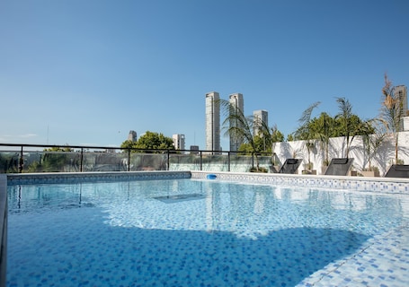 Una piscina al aire libre de temporada, sillones reclinables de piscina