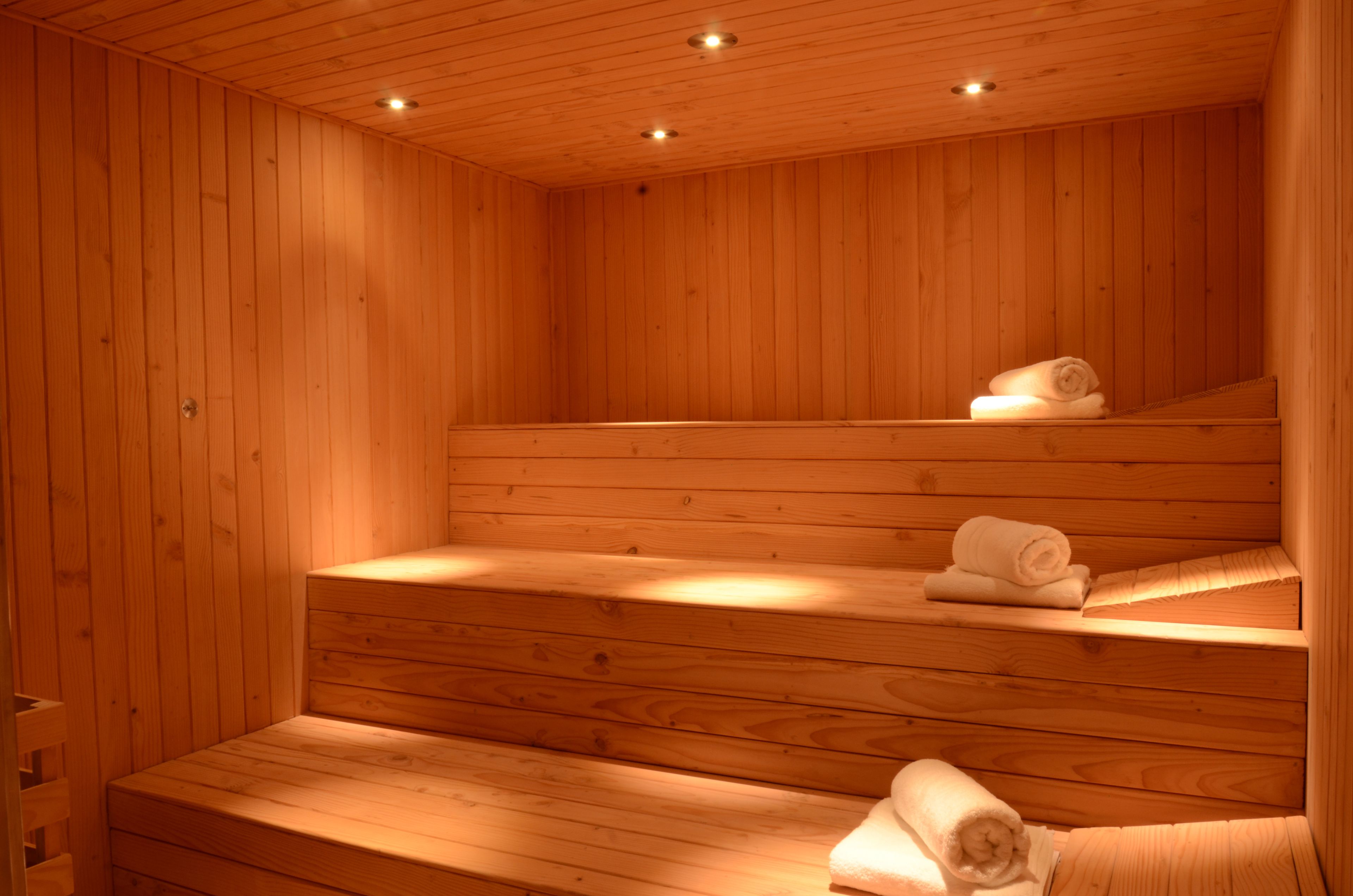 A wooden sauna with benches and towels.