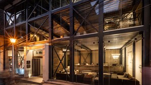 A modern building with large glass windows, a reception area, and a seating area with sofas. - El MaPi Hotel by Inkaterra (Machu Picchu)
