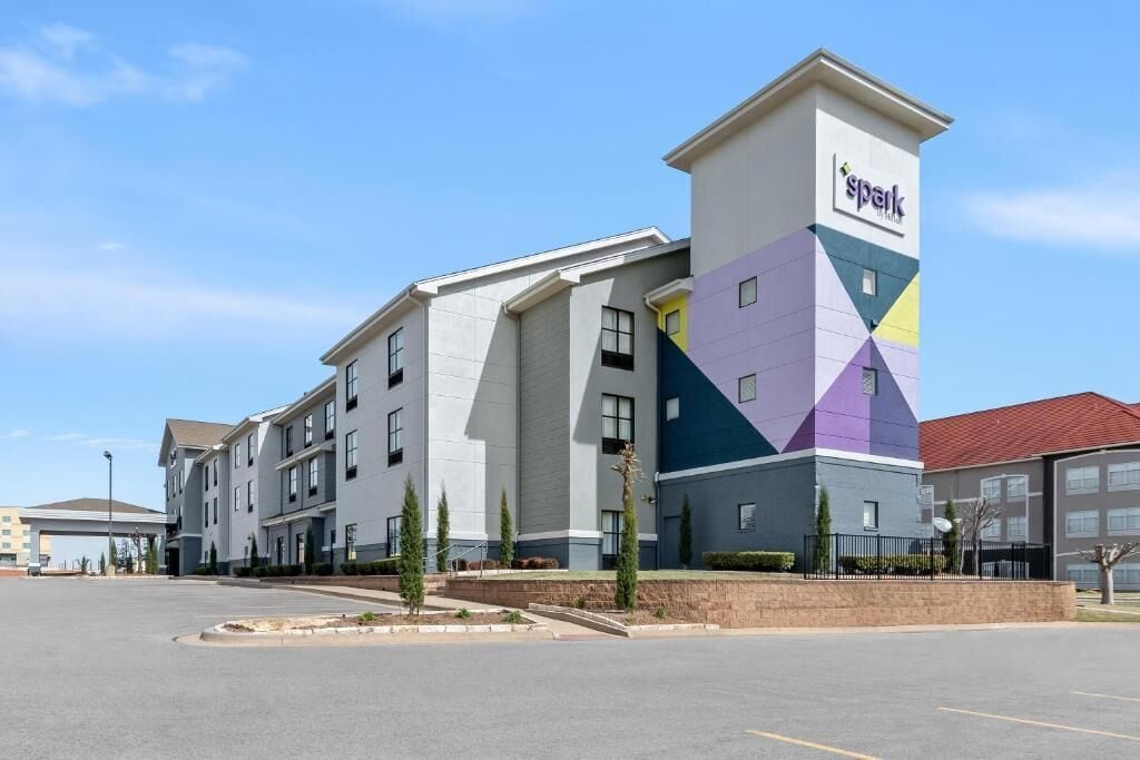 Um hotel de vários andares com design moderno, destacando uma torre com o nome da marca 'Spark'.
