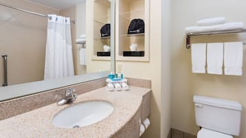 A bathroom with a sink, mirror, towel rack, and toilet.