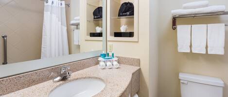 A bathroom with a sink, mirror, towel rack, and toilet.