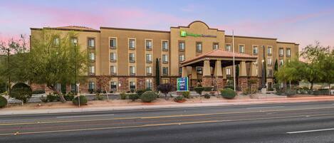 A Holiday Inn Express hotel with a symmetrical facade, multiple windows, and a central entrance with a covered patio.