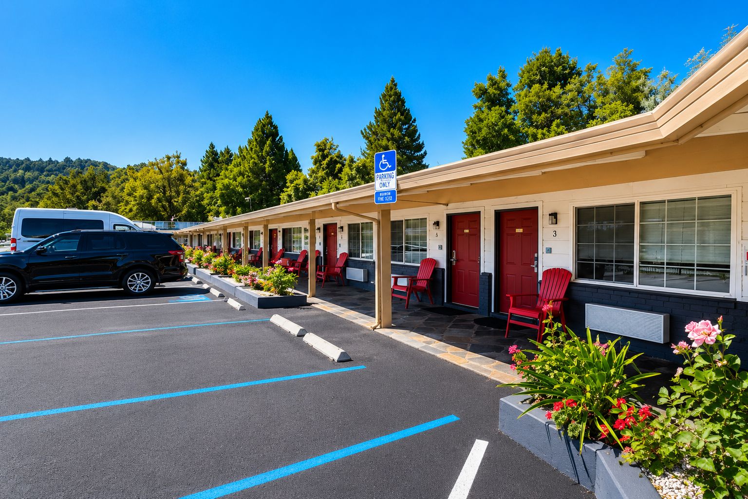 Ein Motel mit Parkplatz, roten Stühlen und einem blauen Parkplatzschild für Rollstuhlfahrer.