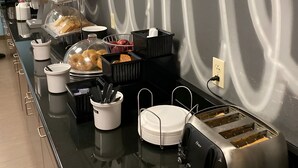 A buffet setup with various food items and a toaster.