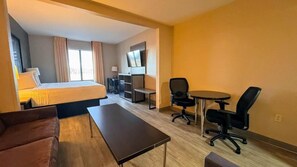 A hotel room with a bed, a desk, a chair, a sofa, and a TV. - Super 8 by Wyndham Pennsville/Wilmington (Pennsville)