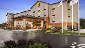 A hotel with a covered entrance, multiple floors, and flags.