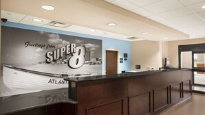 A reception area with a large wall mural, a reception desk, and an ATM.