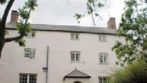 A two-story building with a symmetrical facade, multiple windows, and a central entrance with a small porch. - Church Farm Guest House (Monmouth)