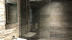 Une salle de bain moderne avec une douche à parois de verre, un lavabo et des toilettes.