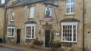 A stone building with a sign reading "Volunteer Inn" and a poster of a person in uniform.
