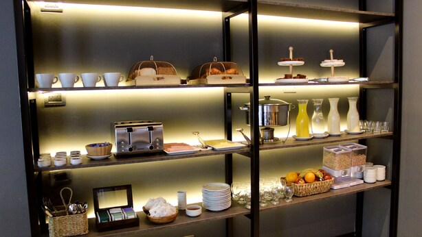 A breakfast buffet with various food items and utensils.