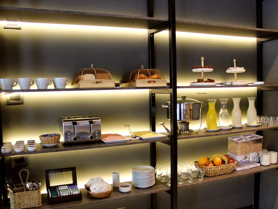 Un bufé de desayuno con diversos alimentos y utensilios.