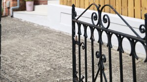 A residential building with a brick facade, a green door, and a wooden fence. - Greenmount Bed & Breakfast (Belfast)