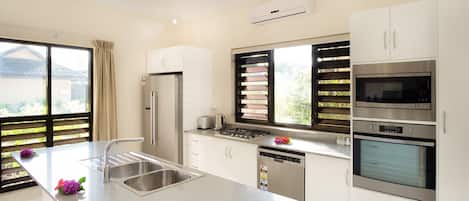A modern kitchen with a stainless steel sink, a built-in oven, and a dishwasher.