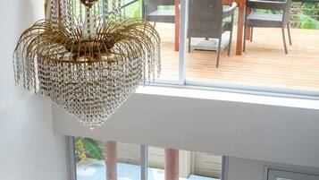 A wooden staircase leading to a balcony with a view of a pool and garden.