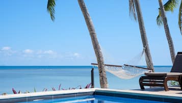 Una piscina al aire libre, sombrillas, tumbonas