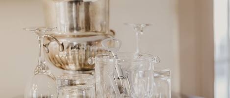 A silver tray with various glassware on a wooden table.