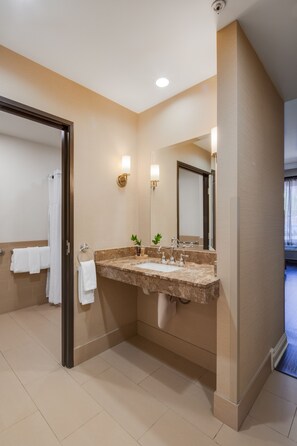 Bathroom features a sink, mirror, and shower area.