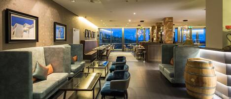 Ein stilvoller Lounge-Bereich mit Sofas, Tischen und einer Bar.