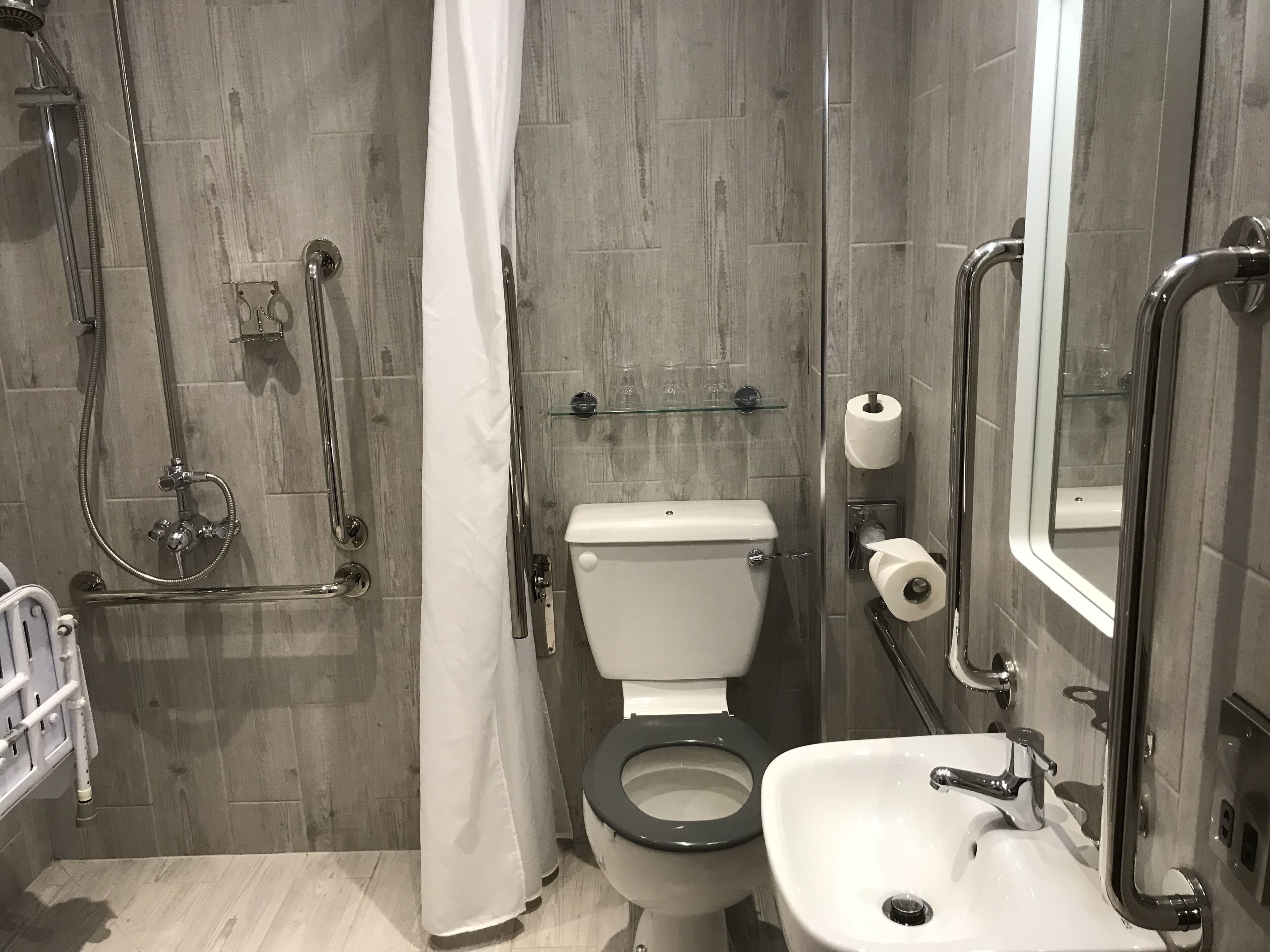 A bathroom with a shower, toilet, and sink.